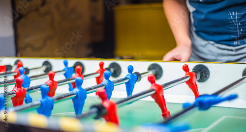 man plays table football. Detail of man's hands playing the kicker