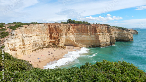 Panoramic view of the ocean cliffs of the Algarve, Portugal, with cloudy blue sky