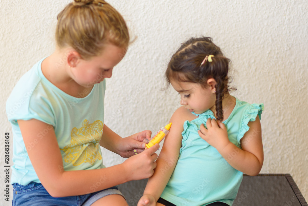 Children playing doctor. Doctor injecting vaccination Flu Shot in arm little child girl, healthy and medical concept.