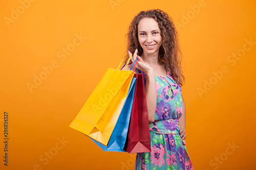 Stylish and shopaholic woman in studio holding bags ov