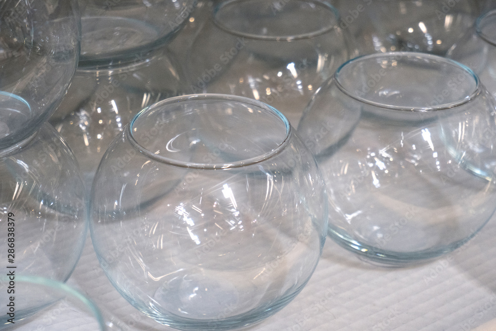 Several rows of transparent empty glass containers without lids. Bunch of vases on a shelf in a store