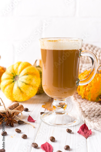 Traditional autumn dishes. Halloween, Thanksgiving. Mug of  hot and spicy aromatic pumpkin latte with whipped cream on top. Ingredients for cook spicy pumpkin latte on white background