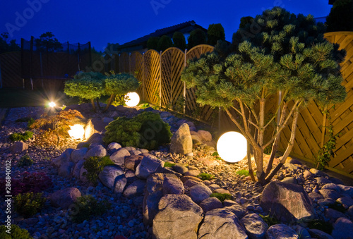Home garden at night, illuminated by globe shaped lights