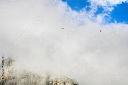 Paragliders floating in clouds over Table Mountain, Cape Town.