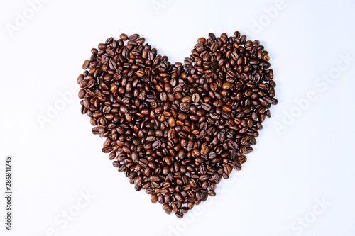Top view roasted coffee beans arranged in heart shape isolate on white background.