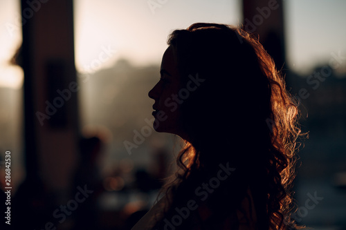 Portrait silhouette of young positive woman with curly hair