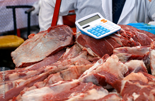 Calculator placed directly on the meat in the Green Bazaar in Almaty, Kazakhstan photo