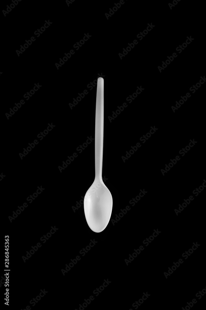 plastic spoon for food on a black background plastic spoon for food on a black background