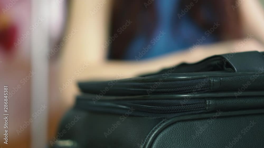 A young European woman chooses clothes in a wardrobe for a tourist trip. Beautiful girl with long hair collects things in a suitcase for travel. Suitcase close-up A young European woman chooses clothes in a wardrobe for a tourist trip. Beautiful girl with long hair collects things in a suitcase for travel. Suitcase close-up