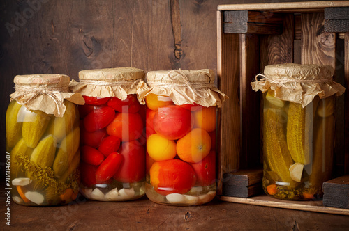 Obraz na płótnie Homemade pickled tomato and cucumber in glass jars in wooden rustic box w salonie