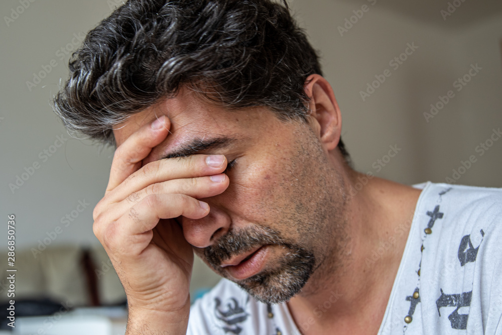 Fototapeta premium Mann mit Hand vor Stirn in Gedanken