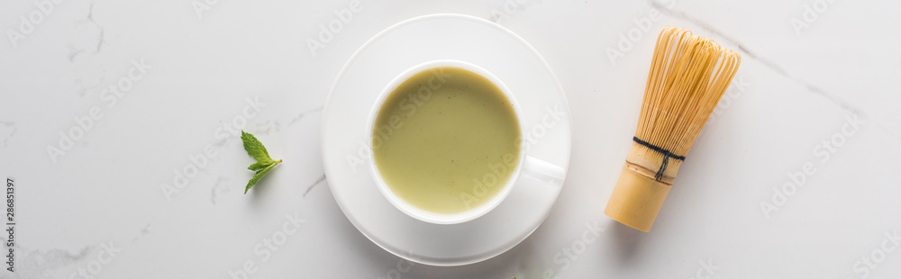 flat lay with cup of green matcha tea on white table flat lay with cup of green matcha tea on white table