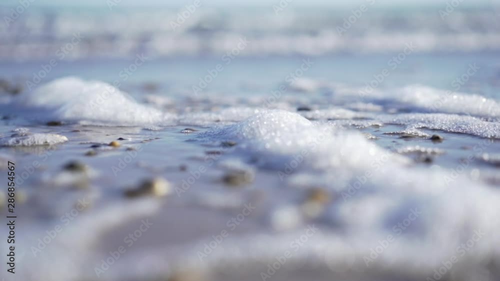 Ocean foam slow motion shot. Cinematic close up at low tide - early morning light Ocean foam slow motion shot. Cinematic close up at low tide - early morning light