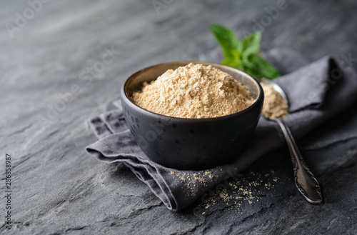 Dietary supplement, Maca root powder in a bowl and spoon with copy space photo