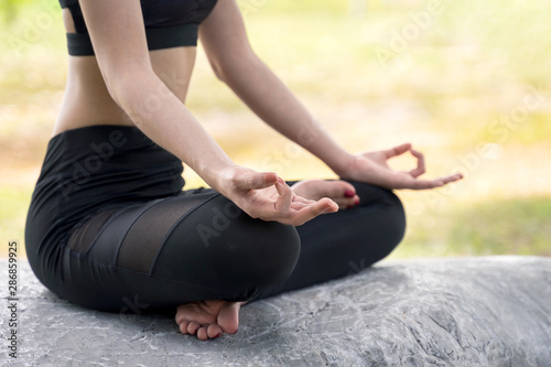 Fototapeta Naklejka Na Ścianę i Meble -  Young beautiful woman practices yoga and meditates outdoor at the mountain. Female doing yoga and meditate to relax and release stress.