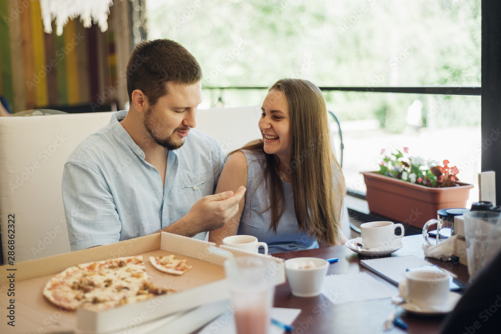 Young man and woman spending time together in pizzeria