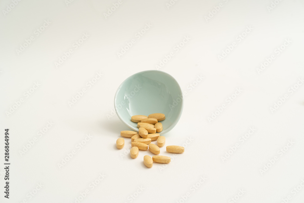 Yellow vitamin pills on white background Yellow vitamin pills on white background