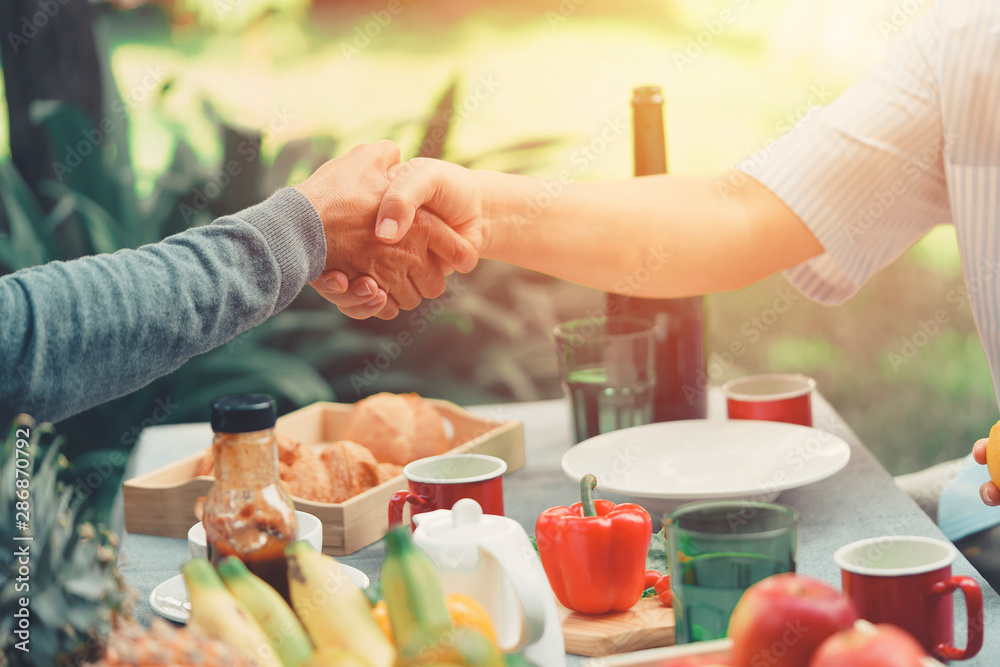 Close up of shaking hands making agreement friendly businessman holding contract. Business partnership meeting concept. Successful Smart Business People handshake after good deal having business lunch Close up of shaking hands making agreement friendly businessman holding contract. Business partnership meeting concept. Successful Smart Business People handshake after good deal having business lunch