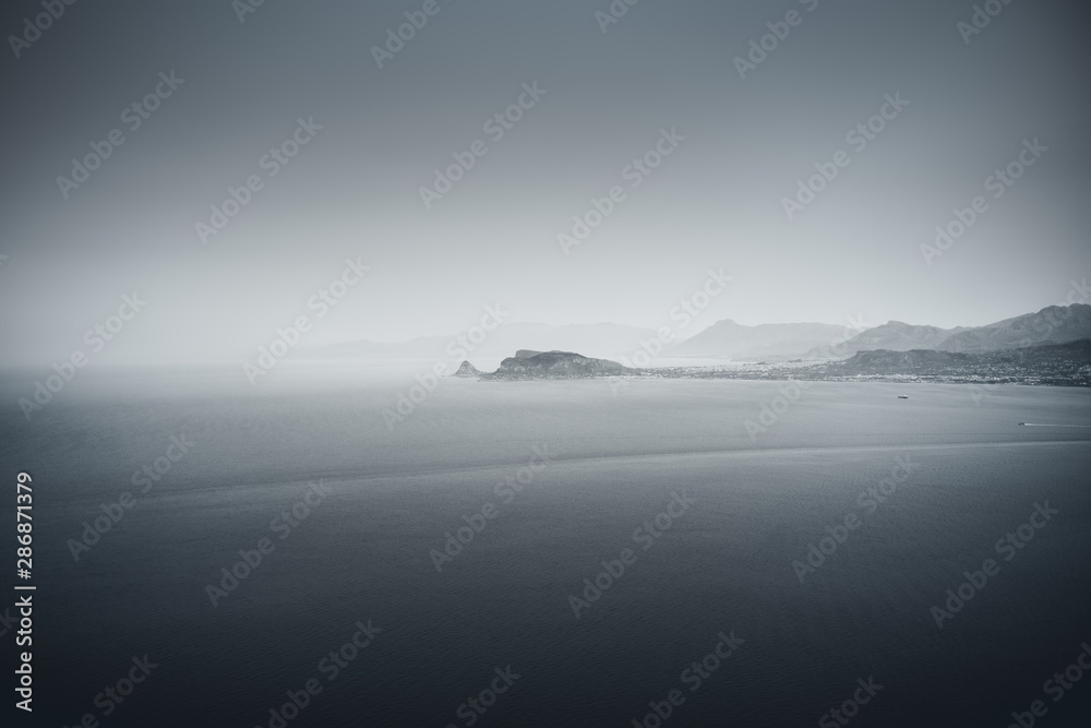 Abendstimmung mit Dunst an einer Küstenlinie mit bild auf Felsen und dem Meer Abendstimmung mit Dunst an einer Küstenlinie mit bild auf Felsen und dem Meer