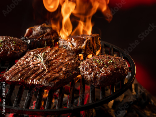 Quadro su tela Top view meat steak assorted cooking on grill background.