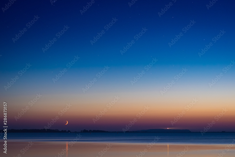 Fototapeta premium Sterne am Himmel über Meer und Insel mit Leuchtturm