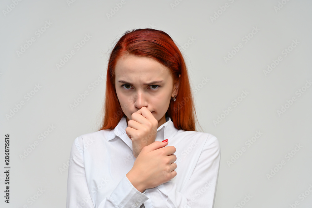 Close-up Portrait of a pretty red-haired girl, a happy young woman manager in a white shirt on a white background in studio. Smiling, showing different emotions. Close-up Portrait of a pretty red-haired girl, a happy young woman manager in a white shirt on a white background in studio. Smiling, showing different emotions.