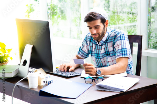 Arab Muslim businessman use the computer at home office. Work at Home concept