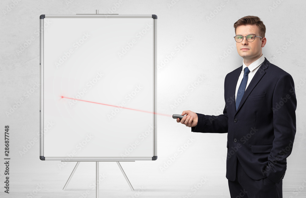 Young businessman with laser pointer and copyspace white blackboard Young businessman with laser pointer and copyspace white blackboard