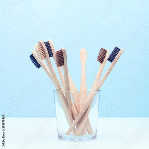 Bamboo toothbrushes in a glass on a blue background  concept zero waste  eco-friendly