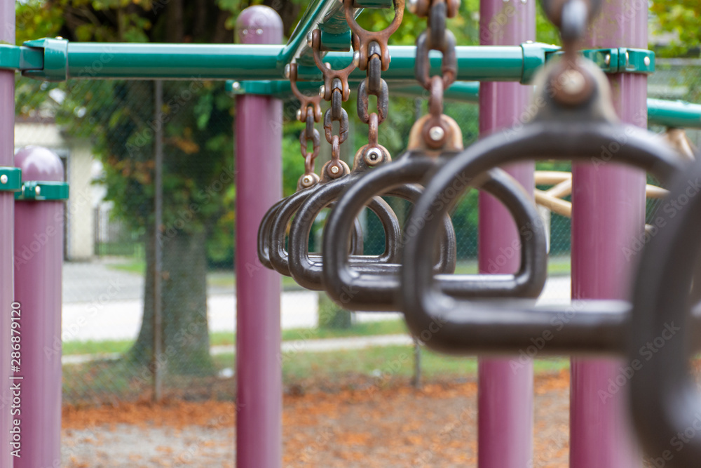 Empty monkey bars at a playground side view concept looking through rings at the goals ahead and holding on strong preventing falling and maintaining balance. Concept.