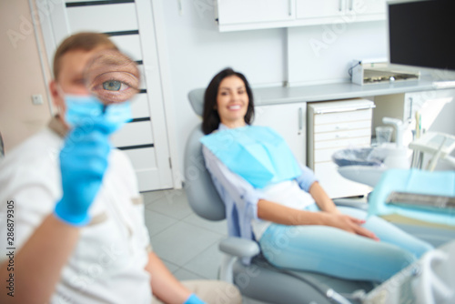 Smiling young lady staying at modern dental office