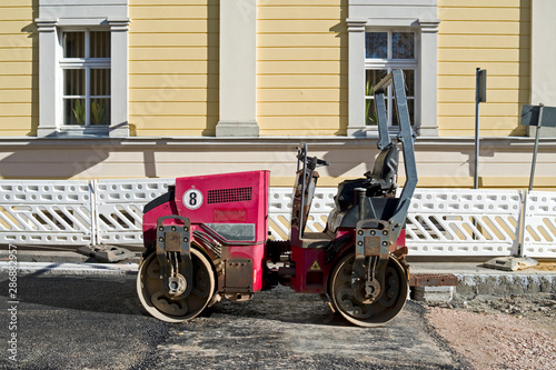 Road Construction / Germany: Small red road roller on the surface of a newly asphalted city street in the New Federal States