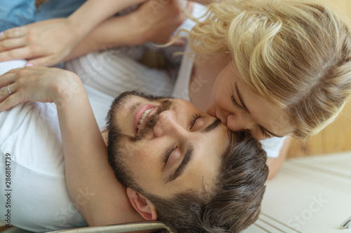 Pretty young woman is kissing bearded man