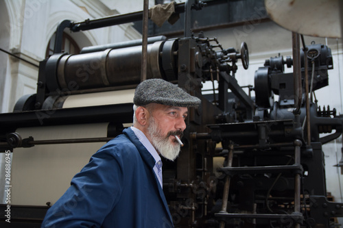 Man with beard working on printing press