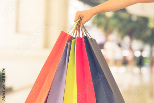 Focus image of woman hand holding colorful shopping bags