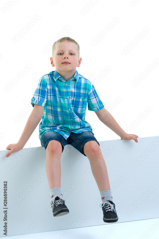 A little boy is looking from behind an empty banner. A little boy is looking from behind an empty banner.