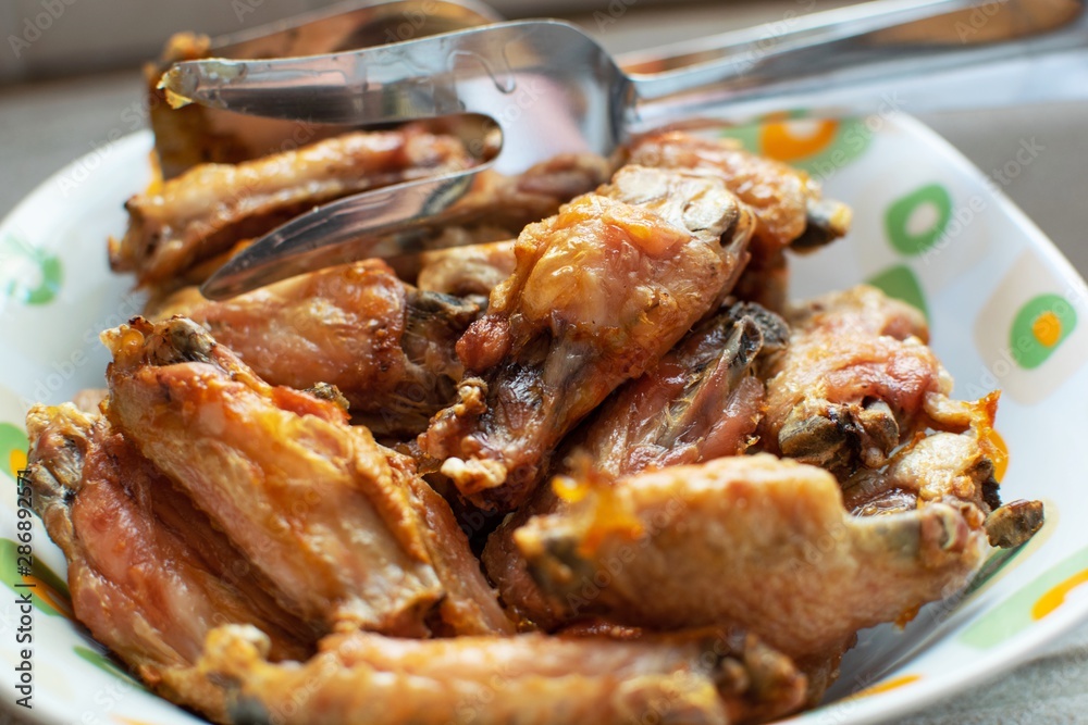 Grilled chicken wings inside a white plate. Grilled chicken wings inside a white plate.
