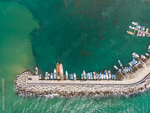 Aerial photo of the boats and marina taken at the small town and seaside resort of Obzor in Bulgaria showing the fishing boats and marina in the ocean on a bright sunny day.