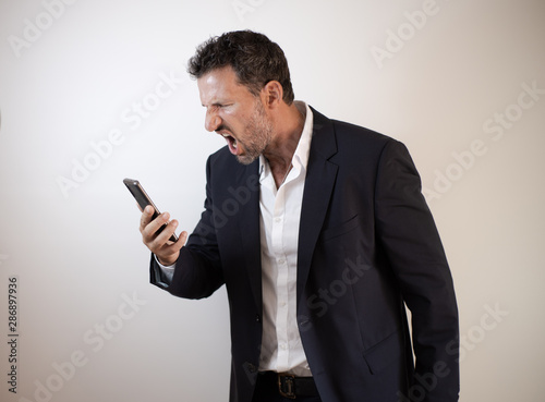 hombre de negocios enfadado y agresivo hablando con el smartphone © Israel