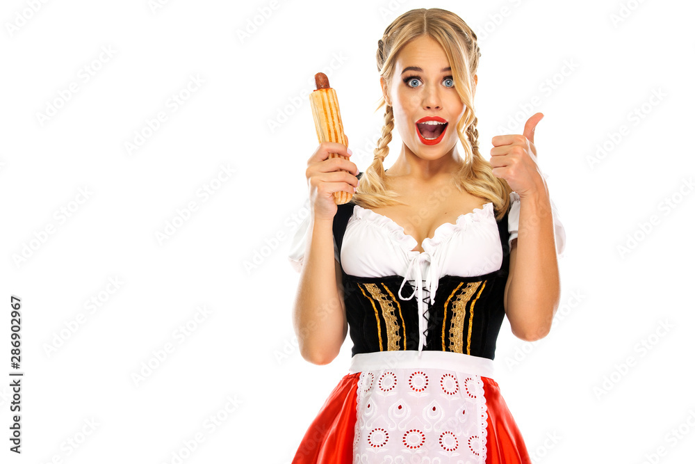 Young sexy Oktoberfest girl waitress, wearing a traditional Bavarian or  german dirndl with french hot dogs isolated on white background. Wow  emotion, woman with thumbs up. – Stock-Foto | Adobe Stock