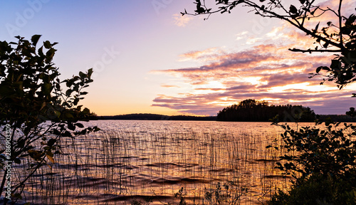 Sunset View on a lake framed by silhouetted trees from the shores of French Lake at Chippewa campground in Quetico Provincial Park, Atikokan, Ontario, Canada photo