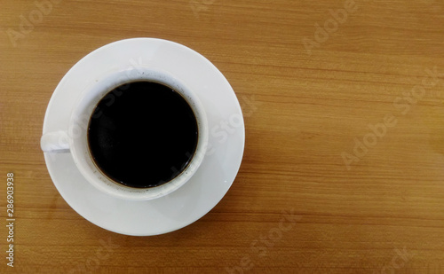 A cup of coffee served on a wooden table