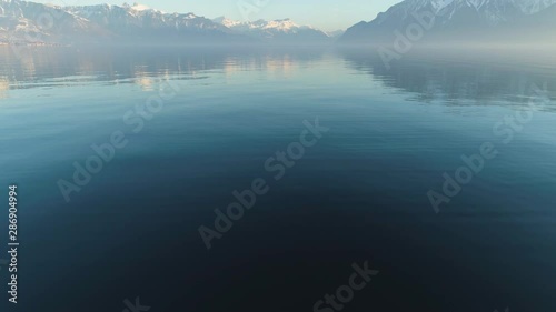 Lake Geneva and Mountains at Clear Day. Swiss Alps. Switzerland. Aerial View. Mountains Reflection. Drone Flies Forward, Tilt Up