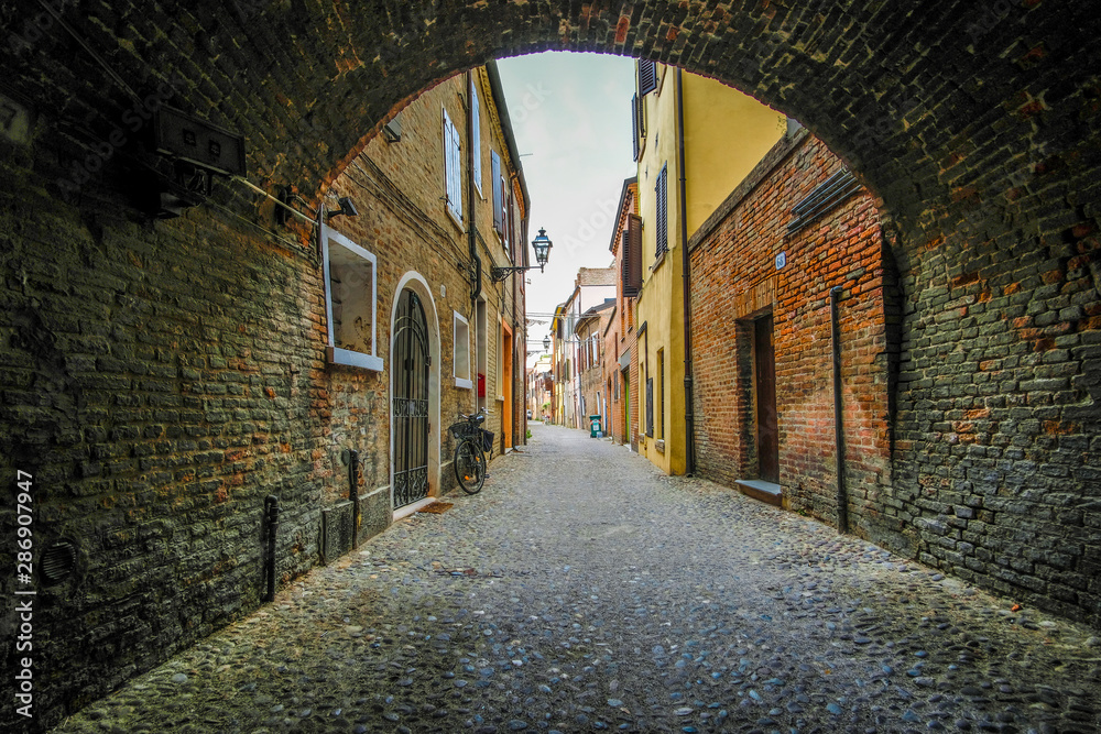 Obraz premium Ferrara, Italy - August, 9, 2019: landscape with the image of a street in a center of Ferrara