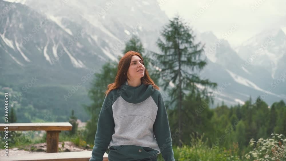Slow motion shot of happy young woman walks in the Dolomites mountains, northern Italy in the summer. Woman traveler. Slow motion shot of happy young woman walks in the Dolomites mountains, northern Italy in the summer. Woman traveler.