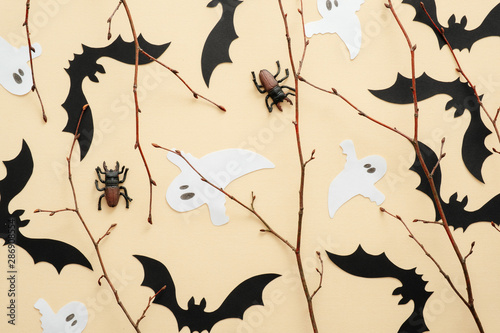 Happy Halloween concept. Halloween decorations  bats  ghosts  spiders on pastel beige background. Halloween party greeting card. Flat lay  top view  overhead.