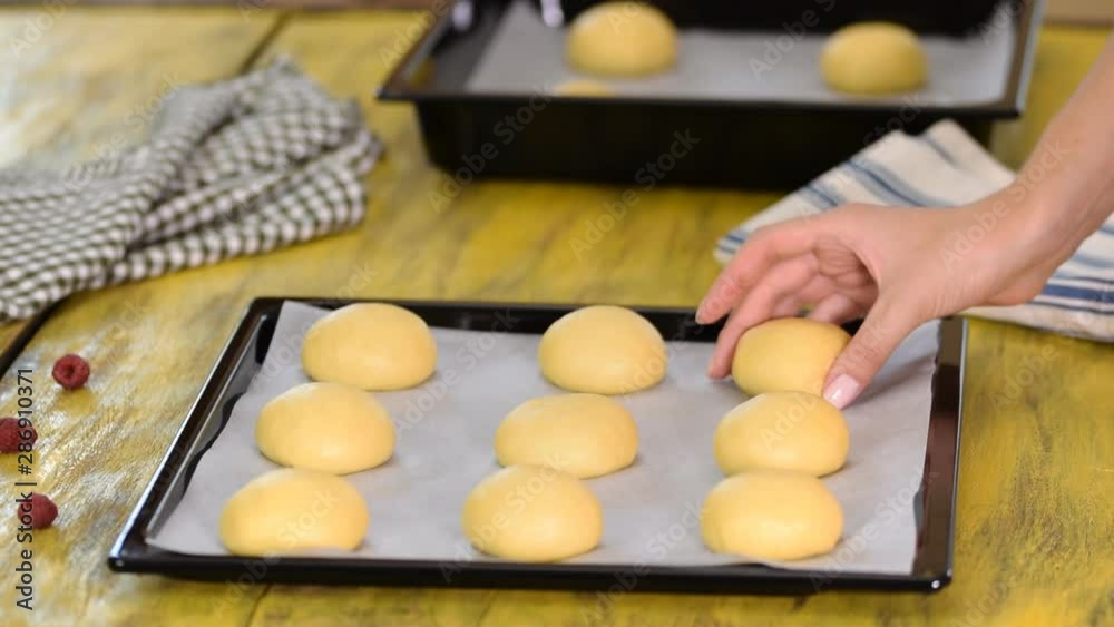 Female baker cooking buns in kitchen. Female baker cooking buns in kitchen.