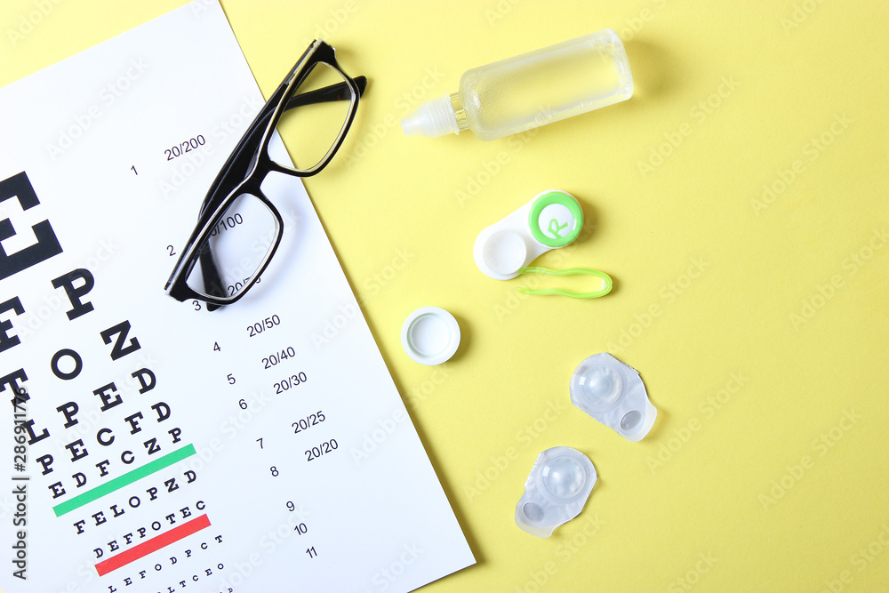 a table for checking vision, glasses and lenses for correcting vision on a colored background, top view. Ophthalmologist Accessories. a table for checking vision, glasses and lenses for correcting vision on a colored background, top view. Ophthalmologist Accessories.
