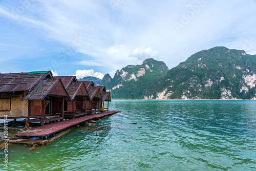 Wooden raft houses on lake with mountain background