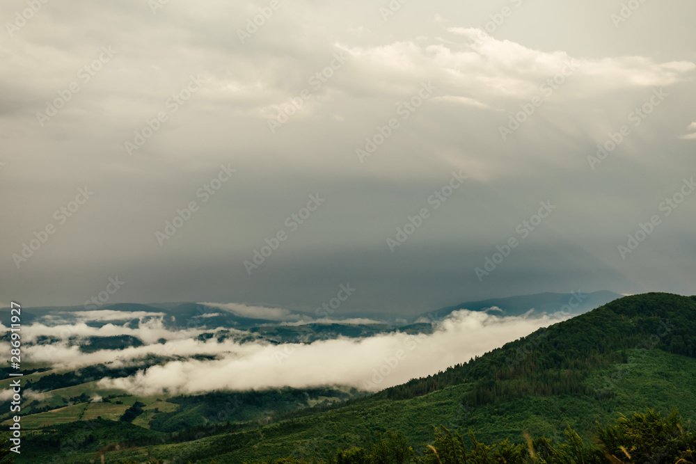 Low mist, fog and stormy clouds over Carpathian mountains
